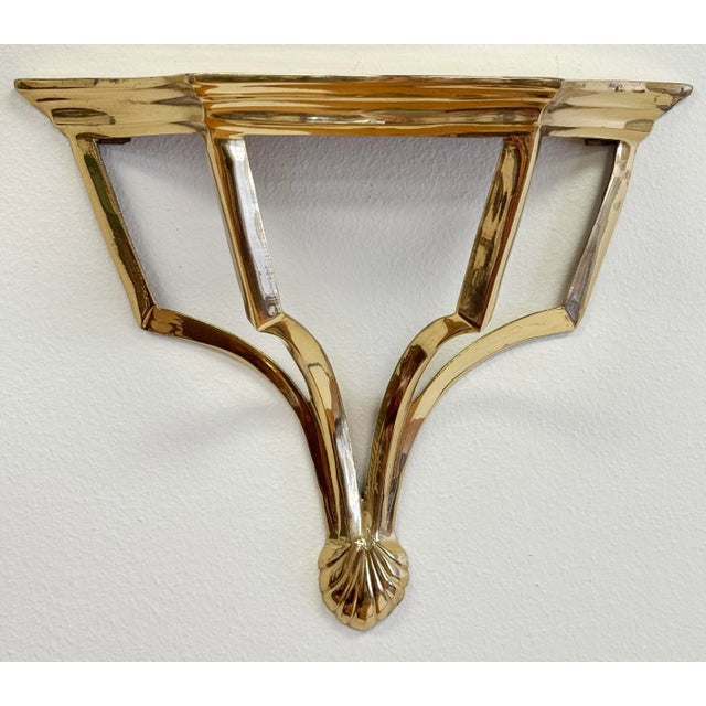 Vintage polished brass wall shelf. Classic shape with shell or fan detail to base. Age wear. Solid brass.