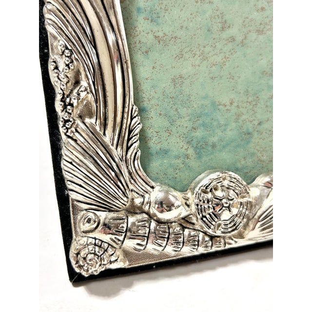 A striking Godinger silver-plated picture frame richly decorated with sculptural seahorses, scallop shells, starfish, and...