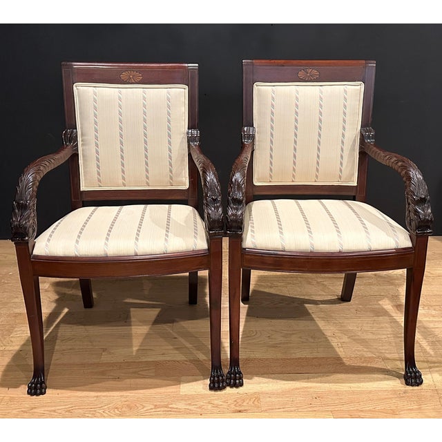 Pair of early 20th century hand carved mahogany armchairs with dolphin form arms. Fan design satinwood inlay on top rails....