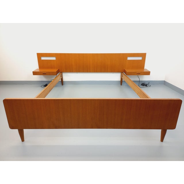 Vintage Scandinavian-style double bed from the 1960s, made of teak, with headboard, frame, footboard, and floating bedside...