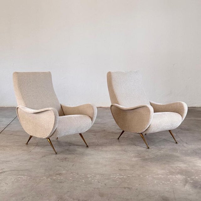 A sophisticated pair of 1950s Italian lounge chairs designed by Gigi Radice and produced by Minotti, evocative of the...
