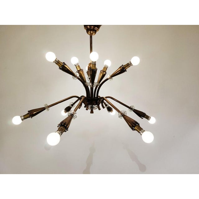 Elegant copper spider or sputnik chandelier with cut glass details. The light shades have a 'curled' finish and the...