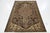 Vintage Handmade distressed hand-knotted wool rug with a brownfield and beige accents in an all-over design. This rug...
