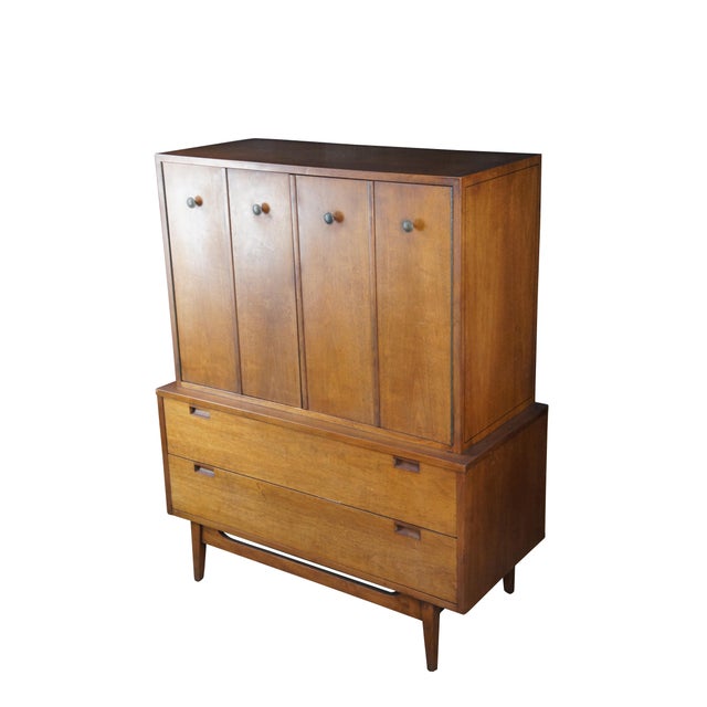 1960s American of Martinsville MCM Chest of Drawers. Features a walnut frame with bifold doors that open to three...