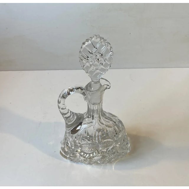 This wine or Port decanter dates to the 1950s or 60s. Its many cut edges are beveled softly. It can contain around 0.7...