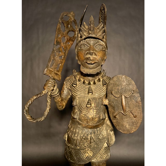 A striking early to mid-20th century cast bronze figure depicting a standing warrior, executed in the traditional lost-wax...