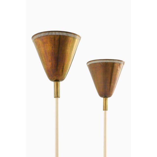 This rare pair of floor lamps, produced in Denmark, exemplifies the principles of mid-century Scandinavian modern design...