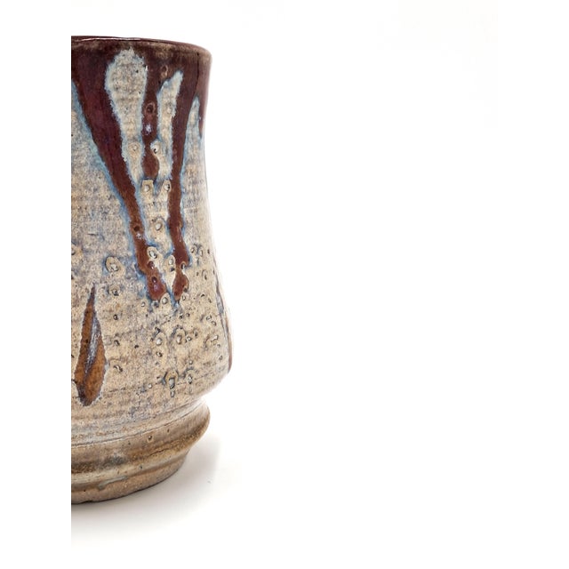 This stunning studio vase features a beige undercoat with an iridescent violet-blue overlay and a rust-colored drip glaze....