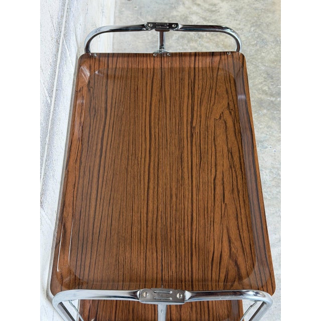 This versatile two-tier foldable bar cart maximizes functionality with a clever collapsible frame. The serving station...