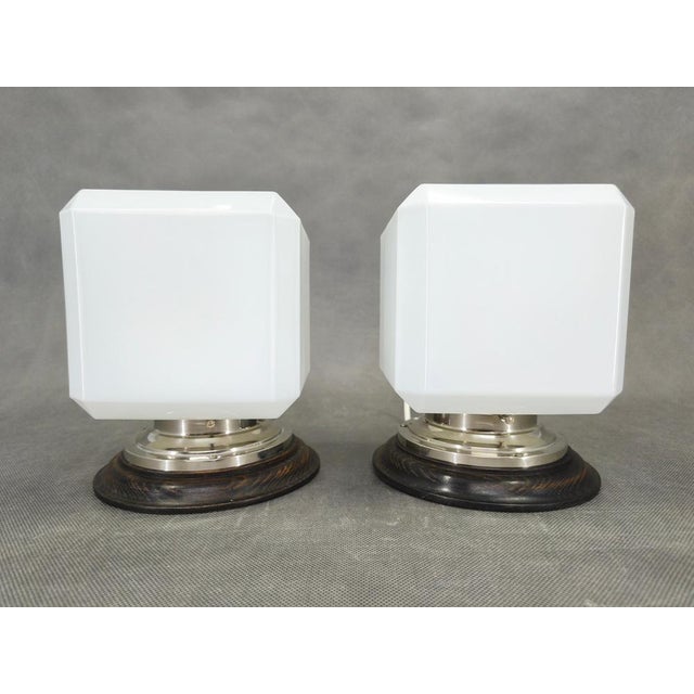 Refined pair of art deco wall lights produced in czechoslovakia during the 1930s. These sculptural sconces combine nickel...