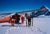 Landing At The Haute Route by Toni Frissell A group of skiers wait by the side of a ski plane at the top of a piste in...