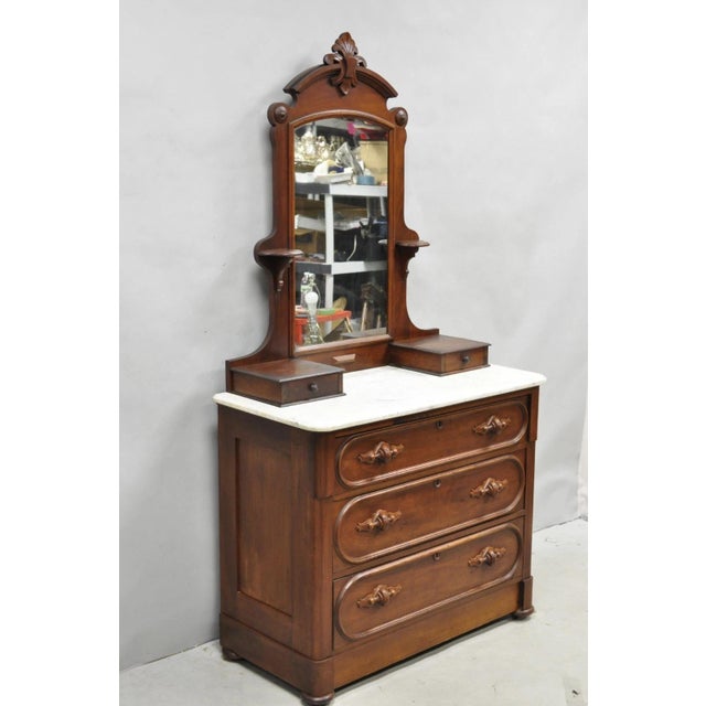 Antique Eastlake Victorian Carved Walnut Marble Top Washstand Dresser w/ Mirror. Item features hidden lower drawer, hand...