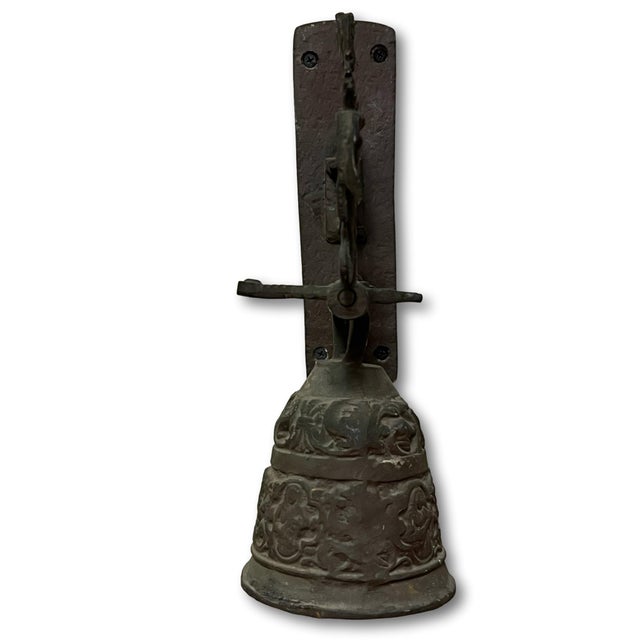 English Gothic Revival sand-cast iron wall bell featuring a relief decorated bell suspended on a protruding bar,...