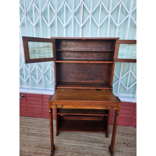 Antique mission Oak wooden secretary desk. Has a hutch with cool stained glass doors on top. Pull-out writing surface and...