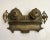 Antique cast brass inkwell features 2 ceramic ink depositories with pen rests, all highly decorated in a Victorian style....