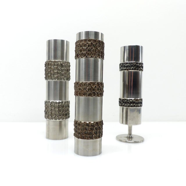 A set of three bmf vases/soliflores dating from the 1970s, combining smooth, cylindrical surfaces in silver-plated metal...