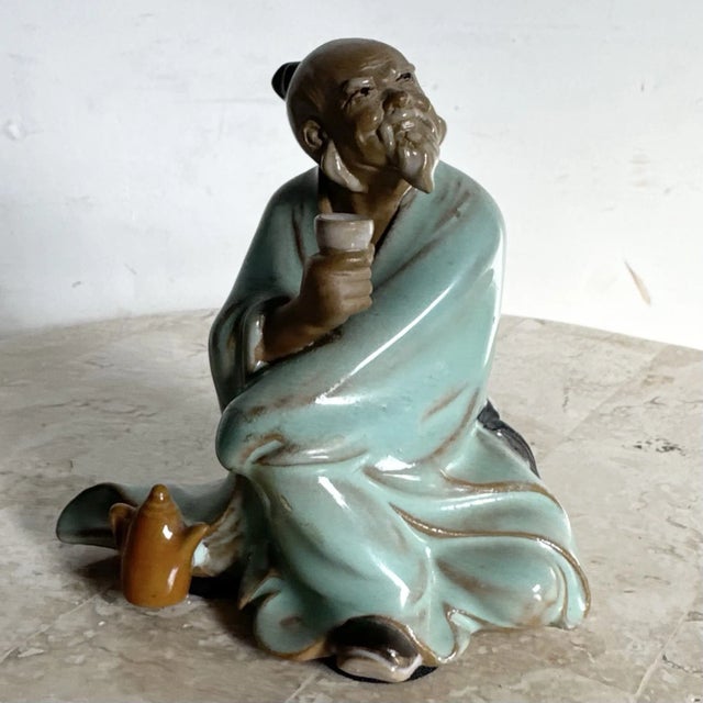 This vintage Chinese pottery figurine depicts a traditional mudman scholar seated in quiet contemplation while enjoying...