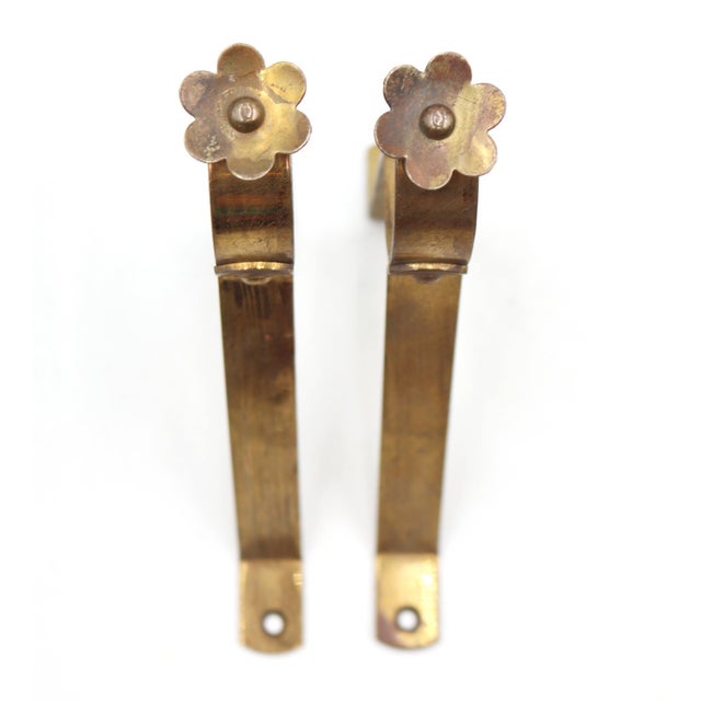 Vintage curtain rod brackets made of brass with a floral screw head. The original mounting screws are not available. Good...