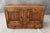 This antique carved oak buffet features richly figured wood, decorative floral carving, fluted panel details, and...