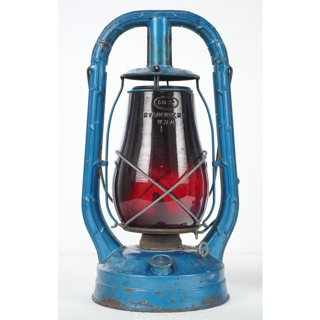 Vintage kerosene lanterns made of a factory blue painted steel body and ruby red glass globes. Both were made by R.E....