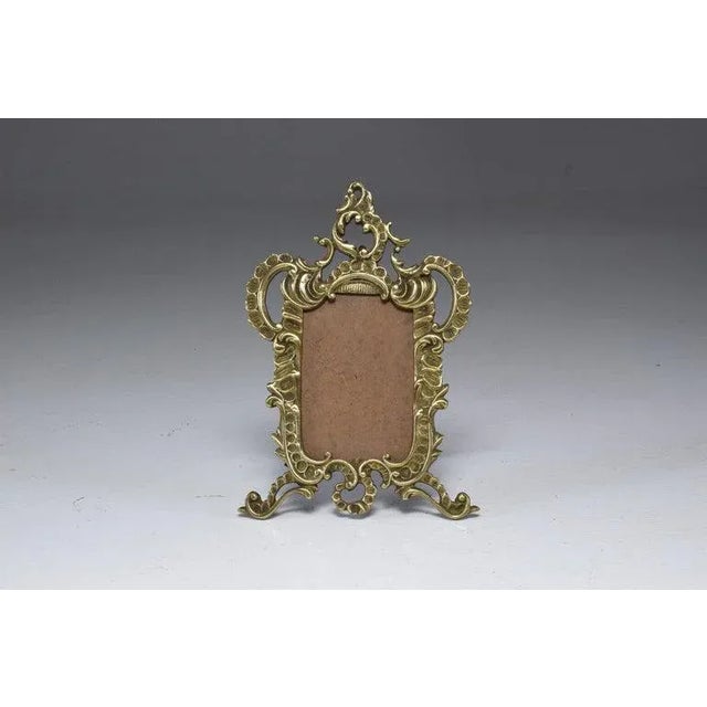 Early 20th-century French cast-brass picture frame in a Victorian-revival vocabulary. Decorative relief and a naturally...