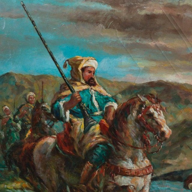 An antique and oversized Orientalist oil on canvas painting depicts soldiers on horseback crossing a river in countryside...