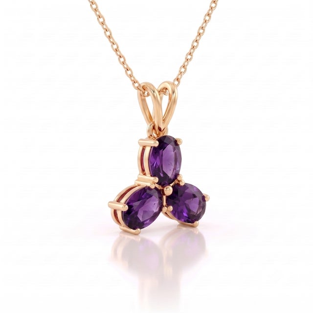 A regal three-stone design featuring oval-cut natural amethysts arranged in a graceful trefoil formation, secured in a...
