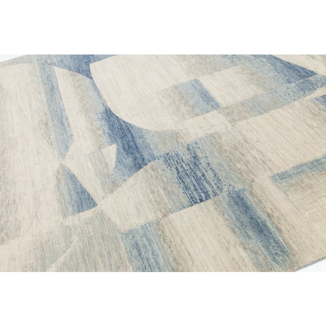 Transform your space with this modern hand-loomed rug, showcasing a blend of organic curves and sharp lines. Crafted from...