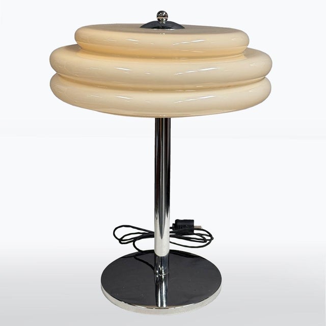 A refined Art Deco table lamp with a classic chrome structure and a distinctive yellow-toned glass shade. The elegant...