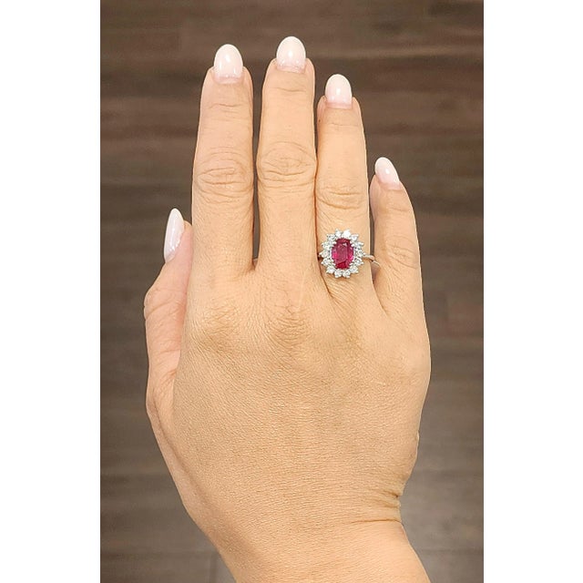 A stunning 2.05 carat natural ruby is exquisitely accented by a halo of 0.60 carats of round brilliant-cut diamonds,...