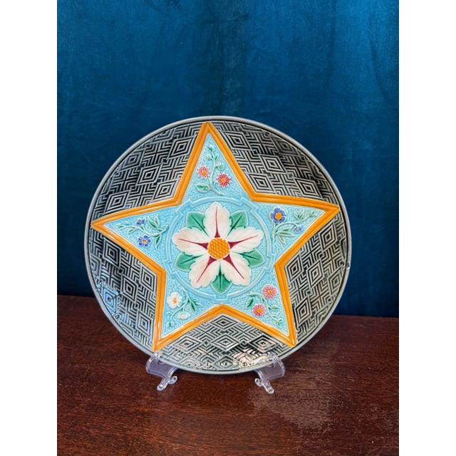 A striking antique Wedgwood Majolica plate featuring an exceptional star-form chrysanthemum design and richly dimensional...