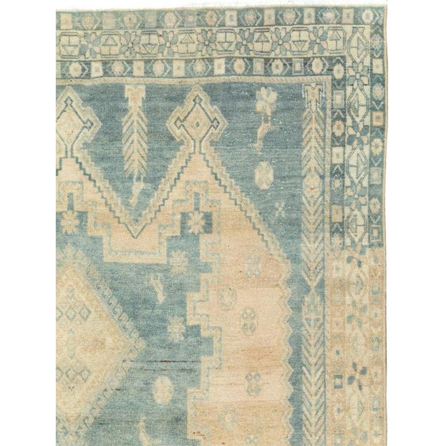This mid-20th-century Persian Afshar rug presents a softly geometric composition in muted blue, ivory, beige, and pale...