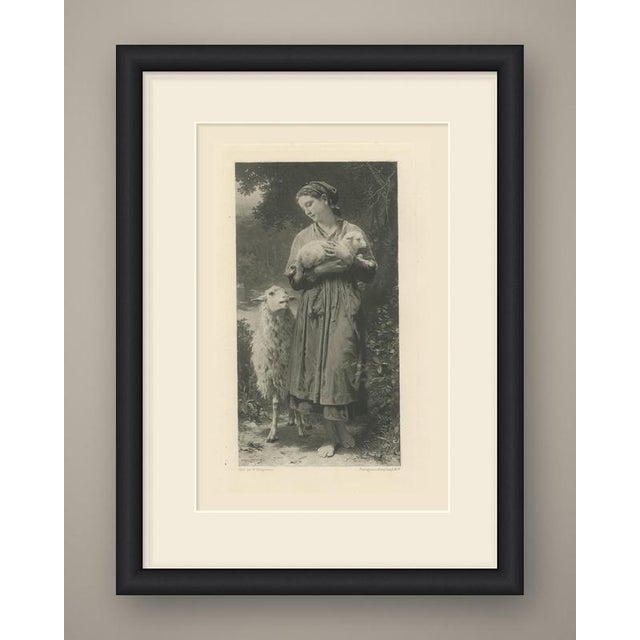 A young shepherdess stands barefoot on a woodland path, cradling a newborn lamb against her chest and looking down at it...