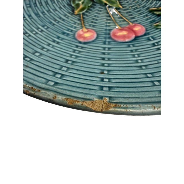 A classic German majolica plate by Georg Schmider of Zell, featuring a raised basketweave pattern and a central motif of...