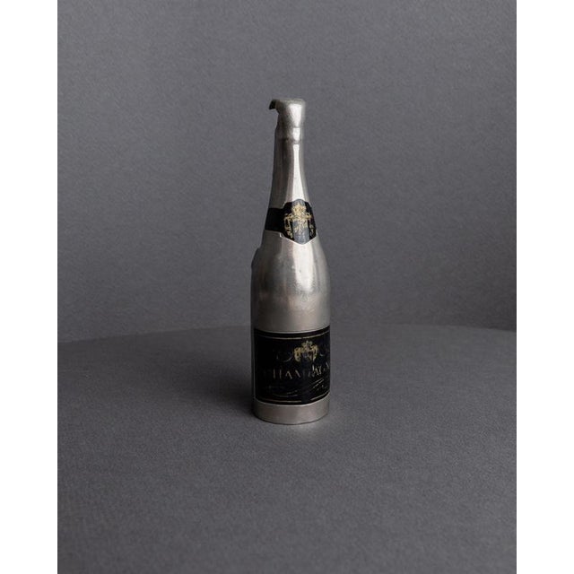 This antique metal bottle opener from 1910s France is designed in the elegant shape of a champagne bottle, featuring...