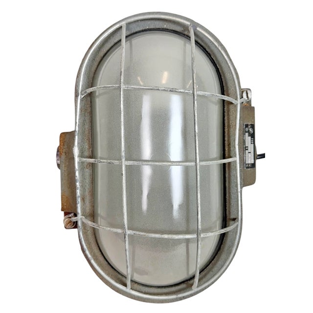 Industrial wall light made by Elektrosvit in former Czechoslovakia during the 1960s. It features a cast iron body, a milk...