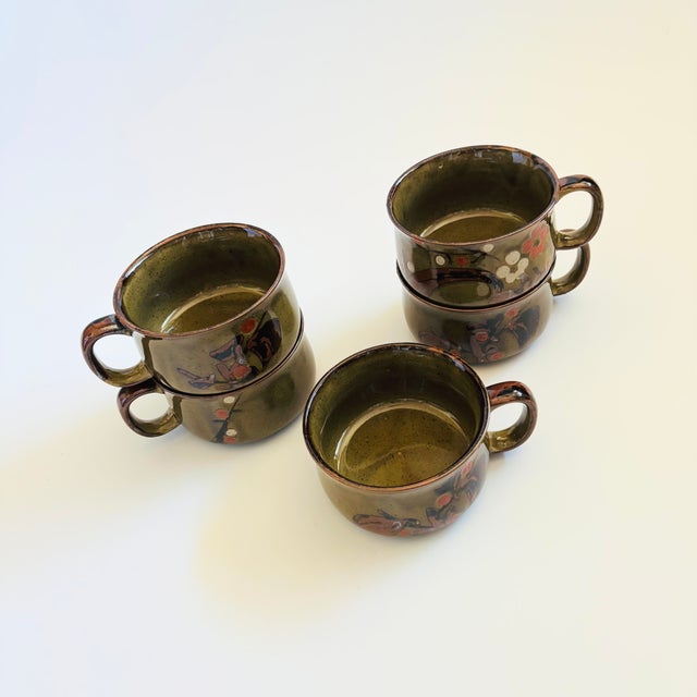 A set of 5 vintage stoneware pottery bowls. Each piece has a handle formed on one side and is finished in dark earthy...