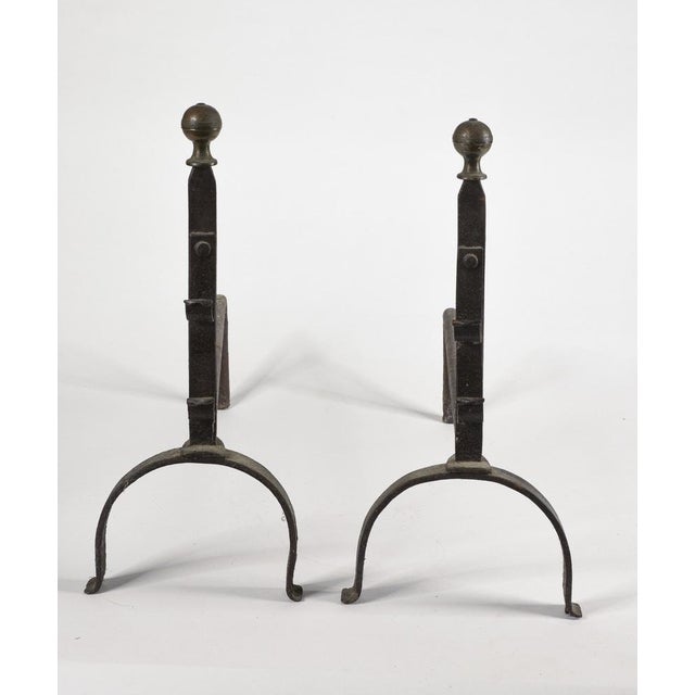 A pair of wrought iron fireplace andirons with a brass knob, dating back to the 19th century. Signs of wear and tear....