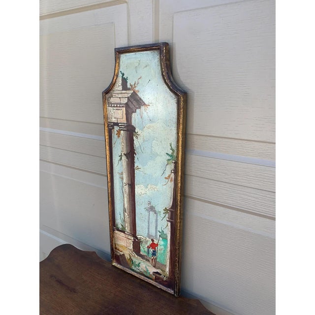 A distinctive Italian capriccio landscape, painted in oil on a shaped panel and presented in a softly worn giltwood frame....