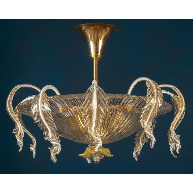 This amazing and rare chandelier centered with a precious hand blown cup, surrounded by a Cascade leaves with gold...