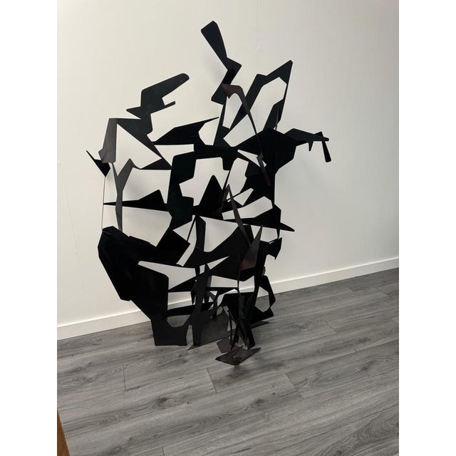 A wonderful abstract art sculpture resembling a flock of birds made entirely from cut and assembled black painted metal by...
