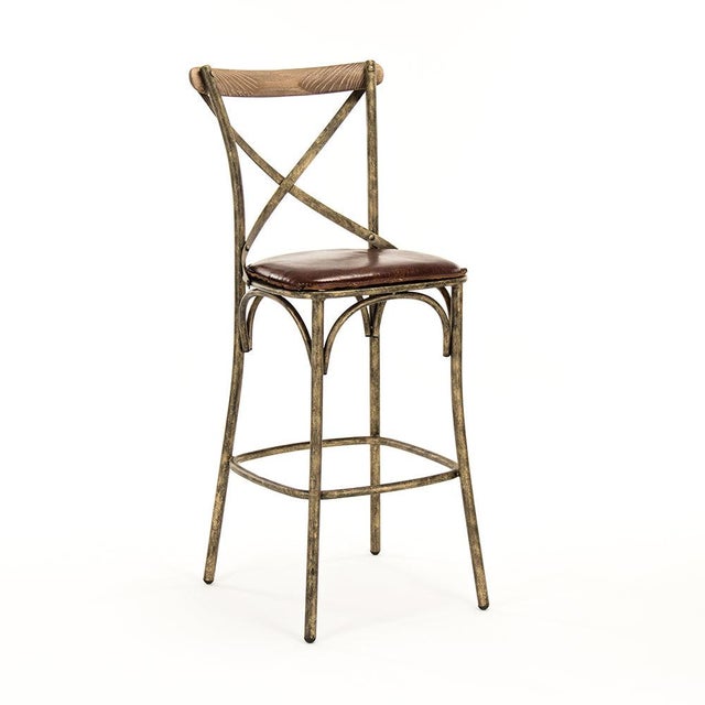 The Manos Bar Stool from Zentique is an industrial bar stool with a top-grain leather seat and curved back on an antique...