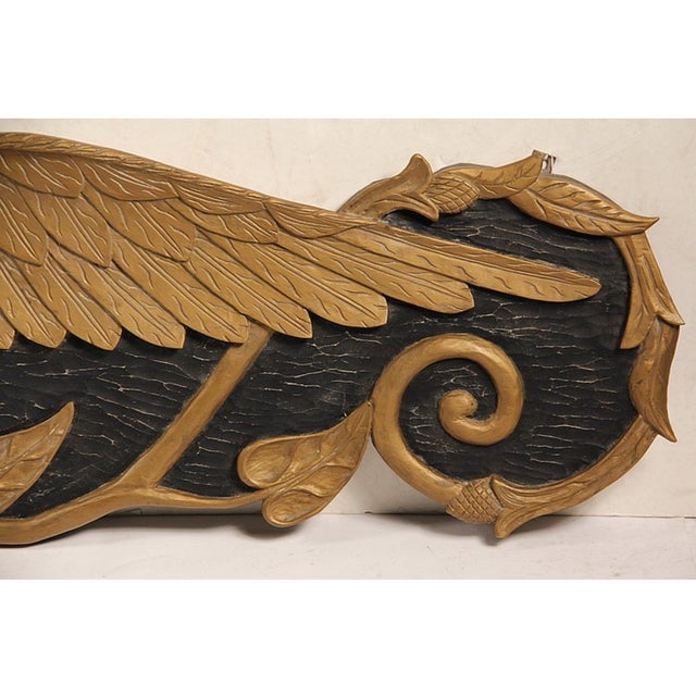 A beautiful 20th Century gilt and black painted carved spread wing eagle stern board signed by ship carver Harold B....