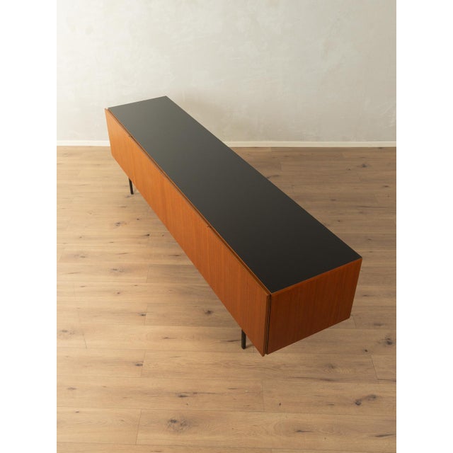 A minimalist sideboard from the 1950s by Dieter Wäckerlin for Behr Möbel. Model B40. Teak veneer body with four cabinet...