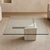 1980s Postmodern Glass Coffee Table With Travertine Base. A sculptural square coffee table pairing a clear glass top with...