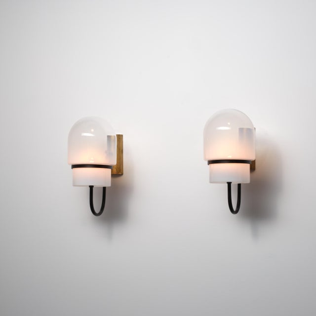 A distinctive pair of italian wall sconces from the 1960s, characterized by a bold and architectural mid-century modern...