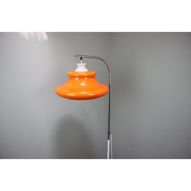 Striking vintage Hungarian floor lamp dating from the 1970s, featuring a sculptural orange plastic shade with a...
