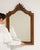 Here is a mirror, its natural wood frame with carved crest, arched the first thing to catch the eye. It was made in France...