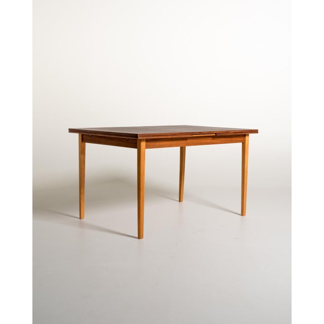 Scandinavian-made table from the 1960s, with an oak frame and a dark lacquered oak top. Two extension leaves. The top has...
