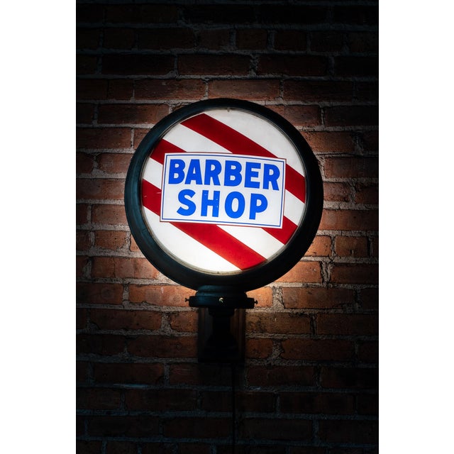 Wall-mounted sconce, internally-lit round barber sign with painted glass lens and cast wall bracket. This mid-century...
